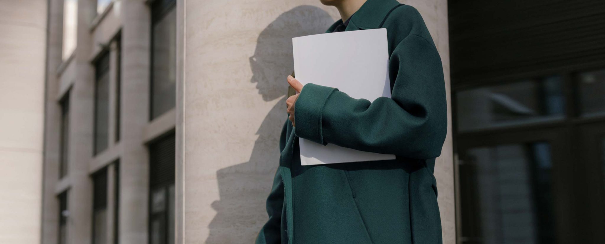 Person holding a folder, standing outdoors.